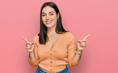 Gündelik giysiler giymiş, kendine güvenen, parmaklarını farklı yönlere çeviren İspanyol bir kadın. reklam için kopyalama alanı 