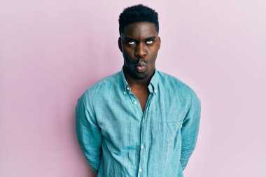 Yakışıklı, sıradan kıyafetler giyen, dudaklarıyla balık suratı yapan, çılgın ve komik bir jest yapan siyahi adam. Komik ifade. 