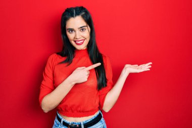 Gündelik kıyafetler giyen genç İspanyol kız kameraya hayret ediyor ve gülümsüyor.. 