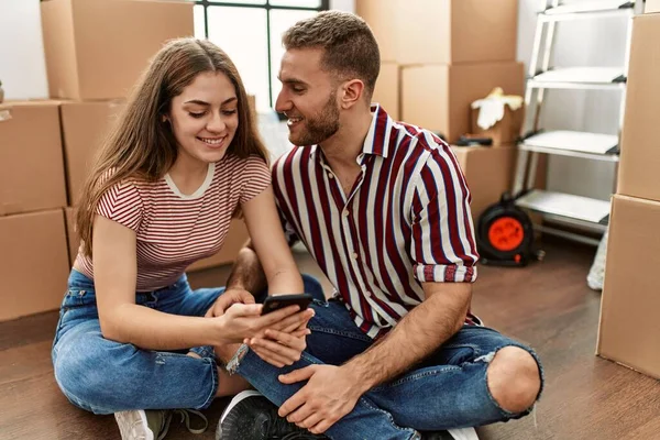 Joven Pareja Caucásica Sonriendo Feliz Usando Teléfono Inteligente Nuevo Hogar — Foto de Stock