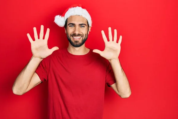 Mladý Hispánec Nosí Vánoční Klobouk Ukazující Ukazující Prsty Číslo Deset — Stock fotografie