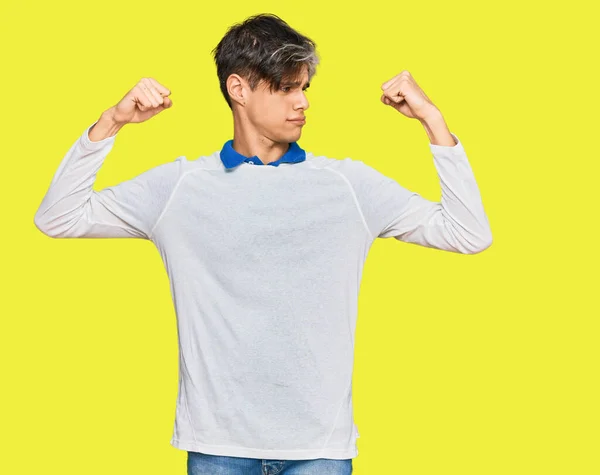 stock image Young hispanic man wearing casual clothes showing arms muscles smiling proud. fitness concept. 