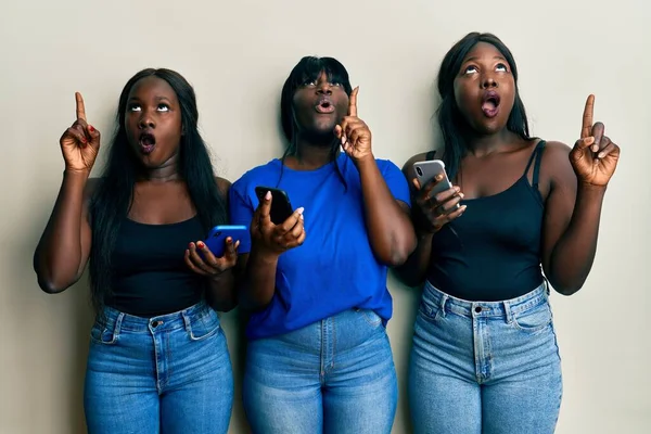 Τρεις Νεαροί Αφροαμερικανοί Φίλοι Χρησιμοποιούν Smartphone Κατάπληκτοι Και Έκπληκτοι Κοιτώντας — Φωτογραφία Αρχείου