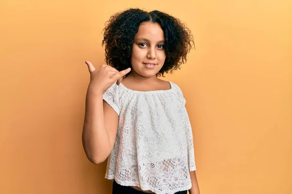 携帯電話で話すような手や指で携帯電話のジェスチャーを行う笑顔カジュアルな服を着てアフロ髪を持つ若い女の子 コミュニケーションの概念 — ストック写真