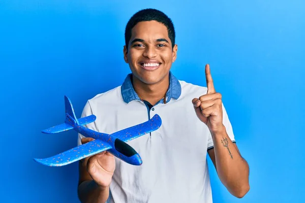 Ung Stilig Hispanic Man Håller Flygplan Leksak Leende Med Idé — Stockfoto