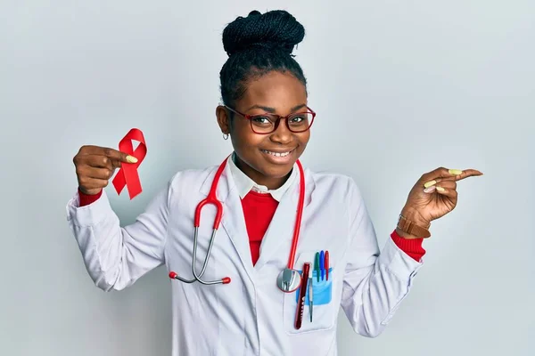 Joven Mujer Afroamericana Vistiendo Uniforme Médico Sosteniendo Apoyo Cinta Roja —  Fotos de Stock