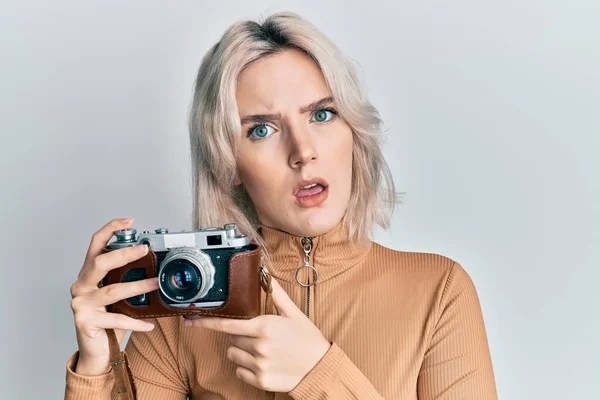 Menina Loira Jovem Segurando Câmera Vintage Rosto Choque Olhando Cético — Fotografia de Stock