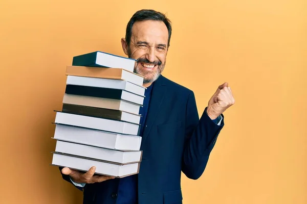 Homem Hispânico Meia Idade Segurando Uma Pilha Livros Gritando Orgulhoso — Fotografia de Stock