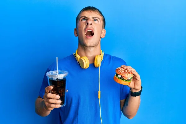 Young Caucasian Man Eating Tasty Classic Burger Soda Angry Mad — Stock Photo, Image