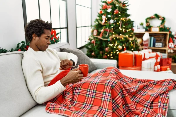 Young African American Man Sitting Sofa Drinking Coffee Christmas Tree — Stock Photo, Image
