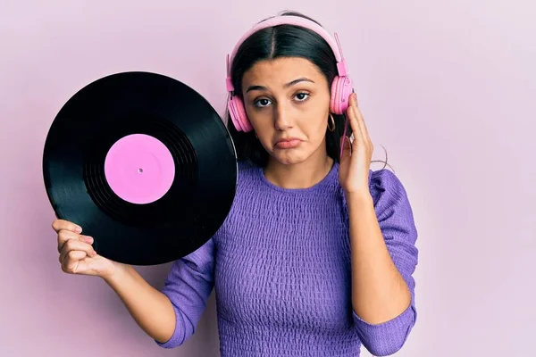 Mulher Hispânica Jovem Usando Fones Ouvido Segurando Disco Vinil Deprimido — Fotografia de Stock