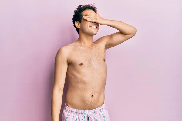Mladý Pohledný Muž Plavkách Bez Košile Usmívající Rukou Tváři Zakrývající — Stock fotografie