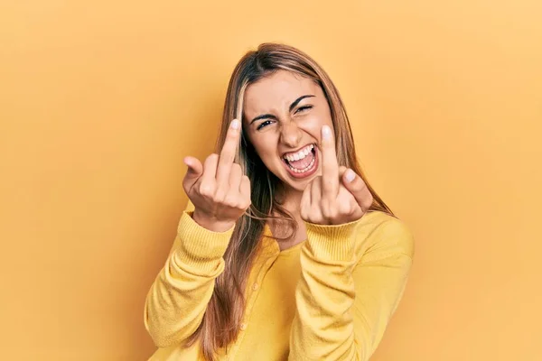 Beautiful Hispanic Woman Wearing Casual Yellow Sweater Showing Middle Finger — стоковое фото