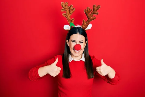 Jovem Hispânica Usando Chapéu Natal Veado Sinal Sucesso Nariz Vermelho — Fotografia de Stock