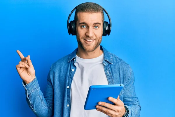 Νεαρός Καυκάσιος Άνδρας Που Χρησιμοποιεί Touchpad Φορώντας Ακουστικά Χαμογελώντας Χαρούμενος — Φωτογραφία Αρχείου