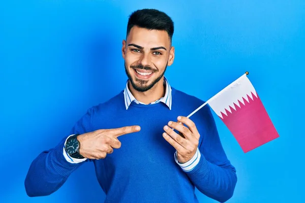 Jovem Hispânico Com Barba Segurando Bandeira Qatar Sorrindo Feliz Apontando — Fotografia de Stock