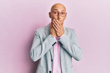 İş kıyafetleri ve gözlük takan kel adam yanlışlıkla elleri ile ağzını kapatırken şok oldu. gizli kavram. 