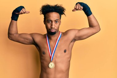 Sakallı, boks yarışmasında birincilik madalyası takan genç Afro-Afrikalı bir adam. Depresyonda ve endişeli, sinirli ve korkmuş. hüzünlü ifade. 