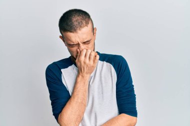 Gündelik kıyafetler giyen İspanyol genç adam pis ve iğrenç bir koku alıyor. Nefesini burnunda tutuyor. Kötü kokuyor. 
