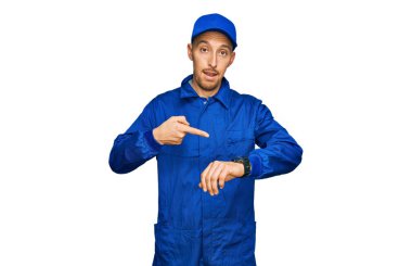 Sakallı, inşaatçı tulumu giymiş kel bir adam. Aceleyle saati, sabırsızlığı ve gecikmeye kızmayı işaret ediyor. 