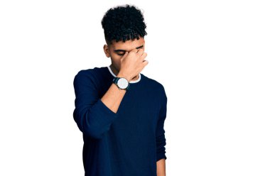 Genç Afro-Amerikan adam günlük kıyafetler giyip yorgun burnu ve gözleri ovuşturup yorgun ve baş ağrısı çekiyor. Stres ve hüsran kavramı. 