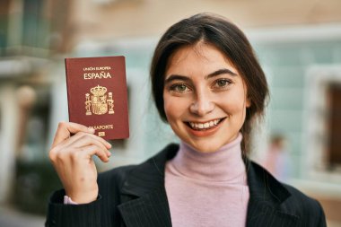 Genç ve güzel iş kadını gülümseyerek şehirde İspanya pasaportu taşıyor..