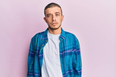 Yüzünde ciddi bir ifade olan gündelik kıyafetler giyen İspanyol genç adam. Basit ve doğal bir şekilde kameraya bakıyorsun.. 
