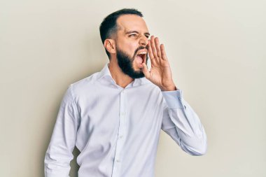 Sakallı genç adam beyaz iş gömleği giyip el ele tutuşarak bağırıyor ve bağırıyordu. iletişim konsepti. 