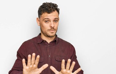 Latin asıllı genç bir adam, sıradan kıyafetler giyip avuçlarını hareket ettiriyor. Korkmuş ve iğrenç bir ifadeyle reddediyor. Dur ve yasakla. 