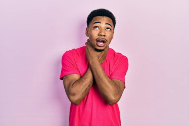 Genç Afro-Amerikan erkek Casua tişörtü giyiyor bağırıyor ve boğuluyor çünkü boğularak can yakıyor. Sağlık problemi. Boğulma ve intihar konsepti. 