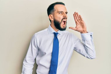 Sakallı genç adam iş kravatı takıyor, bağırıyor ve ağızdan ağıza bağırıyor. iletişim konsepti. 