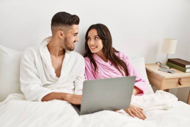 Genç İspanyol çift evde dizüstü bilgisayar kullanıyor..