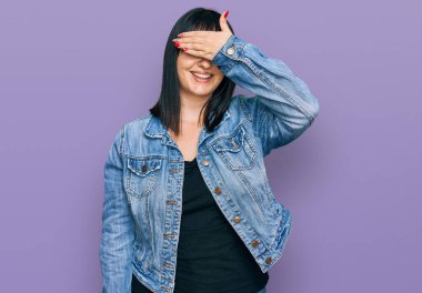 Gündelik kıyafetler giyen, gülümseyen ve gülümseyen genç İspanyol kadın şaşırmak için gözlerini kapatıyor. kör kavram. 