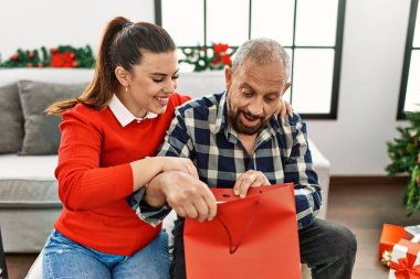 Küçük kız büyük babaya hediye veriyor, Noel 'i evde kutluyor.