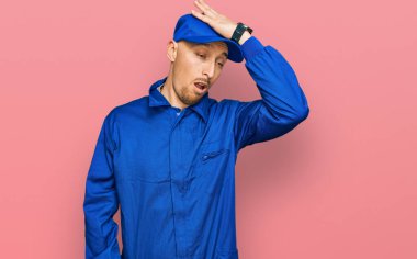 Kel, sakallı, inşaatçı tulumu giyen bir adam. Yanlışlıkla el ele tutuşarak şaşırmış. Hatayı hatırla. Unuttum, kötü hafıza kavramı. 