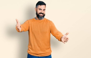 Sakallı, sıradan bir kazak giyen İspanyol adam kameraya sarılıp gülümsüyor. Mutluluğu kucaklayan neşeli bir ifade.. 