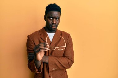 Zarif kıyafetler ve gözlük takan yakışıklı siyahi adam sıkıntılı ve endişeli, sinirli ve korkmuş. hüzünlü ifade. 