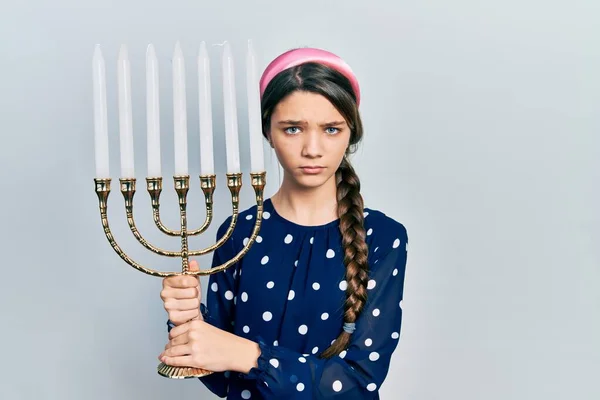 Menina Morena Jovem Segurando Menorah Hanukkah Vela Judaica Cético Nervoso — Fotografia de Stock
