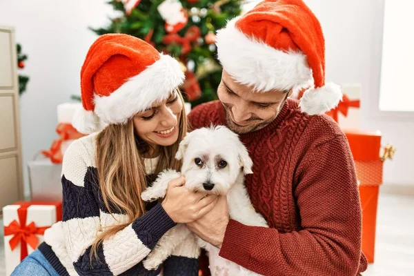 Noel Şapkası Takan Genç Spanyol Çift Evde Köpekle Yerde Oturuyor — Stok fotoğraf