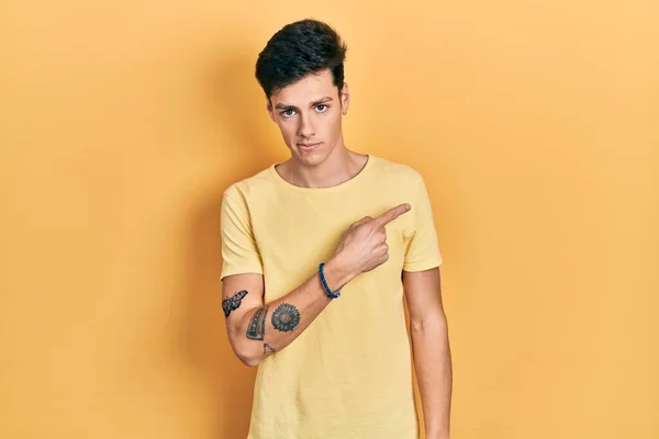 Νεαρός Ισπανός Άνδρας Φορώντας Casual Κίτρινο Shirt Δείχνοντας Χέρι Δάχτυλο — Φωτογραφία Αρχείου