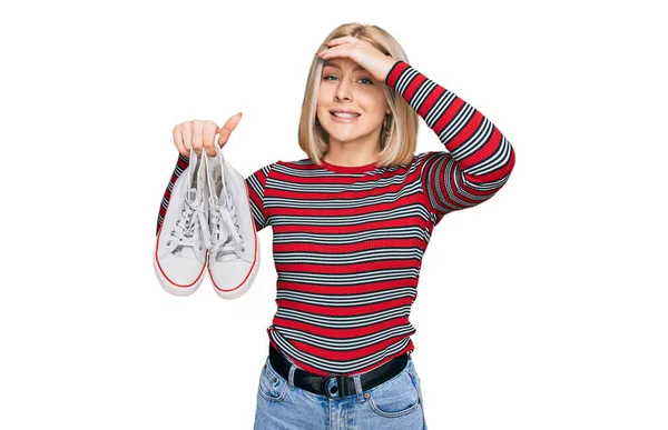 Jovem Loira Segurando Sapatos Casuais Brancos Estressados Frustrados Com Mão — Fotografia de Stock