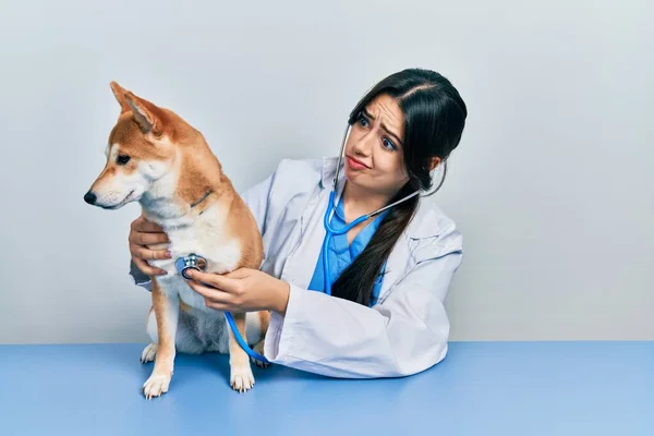 Schöne Hispanische Tierärztin Überprüfung Hund Gesundheit Skeptisch Und Nervös Stirnrunzeln — Stockfoto