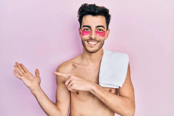 Young Hispanic Man Shirtless Wearing Towel Eye Bags Patches Amazed — Stock Photo, Image