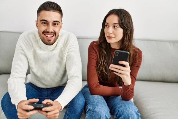 Giovane Coppia Ispanica Giocare Videogioco Utilizzando Smartphone Casa — Foto Stock