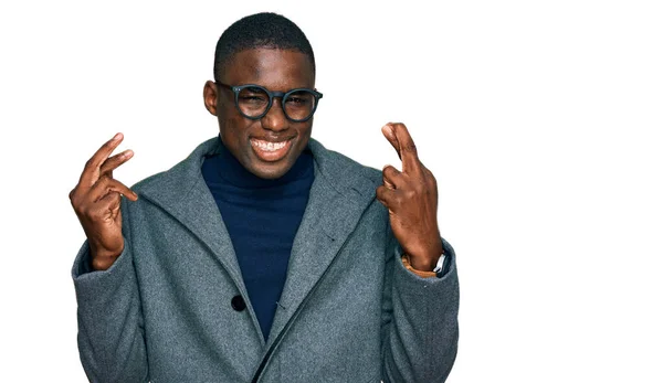 ビジネス用の服を着た若いアフリカ系アメリカ人男性と眼鏡をかける指が希望と目を閉じて笑みを交わした 幸運と迷信の概念は — ストック写真