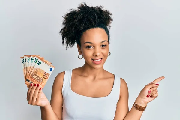 Młoda Afroamerykanka Trzymająca Banknoty Euro Uśmiechnięta Uśmiechem Dłoni Palcu — Zdjęcie stockowe