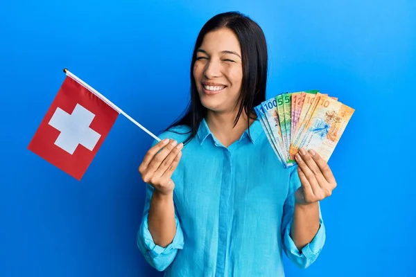 Mladá Latinská Žena Držící Švýcarskou Vlajku Frankové Bankovky Mrkající Fotoaparát — Stock fotografie