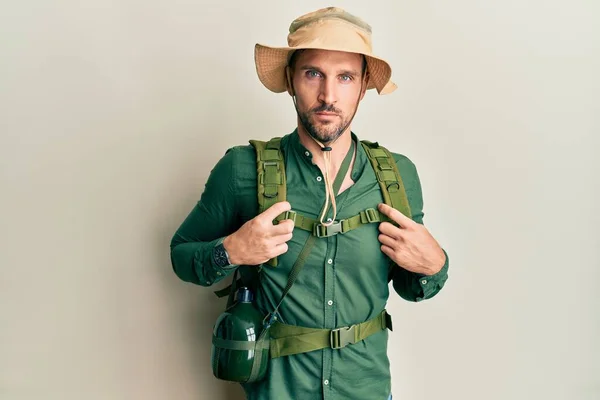 탐험가 모자를 가방을 수염을 기르고 표정으로 긴장을 잘생긴 카메라를 자연스럽게 — 스톡 사진