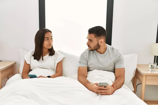 Jovem Casal Latino Usando Smartphone Deitado Cama Casa — Fotografia de Stock