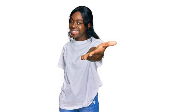 カジュアルな白いTシャツを着た若いアフリカ系アメリカ人女性が挨拶や歓迎として握手を提供笑顔 成功したビジネス — ストック写真